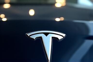 Nahaufnahme des glänzenden Logos eines Tesla-Fahrzeugs, professionell gereinigt